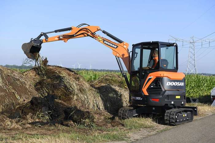 the new style Develon DX35z mini excavator digging grass and mud